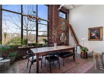 Bright dining room with exposed brick wall, large windows and unique chandelier at 174 Chester Se Ave # 127, Atlanta, GA 30316