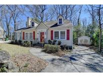 Charming home with light yellow siding, red shutters, dormer windows, and a stone walkway at 2953 Hardman Ne Ct, Atlanta, GA 30305
