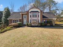 Charming brick home with manicured lawn and bay window feature at 795 Saddle Ridge Trce, Roswell, GA 30076