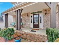 Inviting front porch with brick facade, decorative columns, and seating area at 108 Rex Ave, Canton, GA 30114