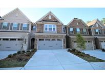 Charming brick townhome featuring attached garages and well-manicured front lawns at 680 Mason Grove Pkwy, Lawrenceville, GA 30043