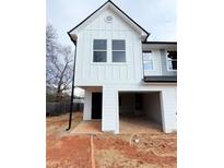 Modern two-story home featuring white siding, black trim, and an open garage at 11602 E Lovejoy Rd, Hampton, GA 30228