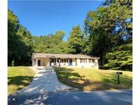 Charming single story home with a well-manicured lawn, complemented by lush trees and a long driveway at 3263 Dodson Dr, Atlanta, GA 30344