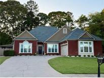 Charming brick home with well-manicured lawn, inviting curb appeal and covered car port at 60 Saddle Tree Way, Sugar Hill, GA 30518