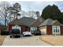 Charming one-story brick home featuring manicured landscaping, a gray roof, and a two-car garage at 60 Saddle Tree Way, Sugar Hill, GA 30518