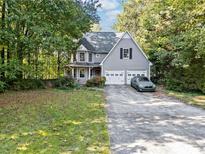 Charming two-story home with mature trees, two-car garage and a long driveway at 395 Lake Swan Ct, Hiram, GA 30141