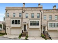 Attractive brick townhome exterior with large windows, garage, and inviting entrance stairs at 3715 Peachtree Ne Rd # 2, Atlanta, GA 30319