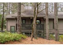 Inviting exterior view of home with a covered porch, complemented by mature trees and lush landscaping at 1901 Cumberland Ct, Smyrna, GA 30080