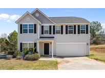Charming two-story home featuring a gray exterior, black shutters, and a well-maintained front yard at 260 Heaton Dr, Covington, GA 30016
