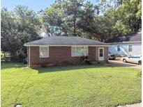 Charming brick home with a well-maintained lawn and mature trees in a quiet neighborhood at 212 Austin Ne Ave, Marietta, GA 30060