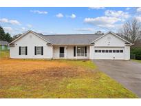 Charming single-story home with white siding, attached garage and well-maintained lawn at 331 Cobblestone Rd, Auburn, GA 30011