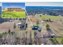 Sprawling property featuring a well-maintained home with a wrap around porch and mature trees at 5692 Rock Patch Rd, Loganville, GA 30052