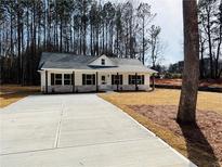 Charming single-story home with a well-manicured lawn and long concrete driveway at 488 West Ave, Bowdon, GA 30108