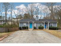 Charming duplex featuring a symmetrical design, well-maintained lawn, and inviting blue doors at 1276 Scripps Sw Ct, Marietta, GA 30008