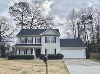 Charming two-story home featuring a manicured lawn, attached two-car garage, and a classic suburban aesthetic at 738 Windsor Cir, Lawrenceville, GA 30046