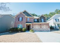 Charming two-story brick home with a well-manicured lawn and a two-car garage in a suburban neighborhood at 1092 Park Hollow Ln, Lawrenceville, GA 30043