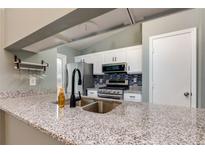 Updated kitchen featuring granite countertops, stainless steel appliances, and blue tile backsplash at 1341 Inman Ct, Norcross, GA 30093