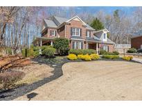 Charming two-story brick home featuring a beautifully landscaped front yard and covered porch at 2802 Nettle Ln, Buford, GA 30519