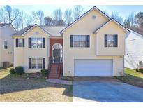 Charming two-story home featuring a well-maintained front yard and a two-car garage at 375 Tambec Nw Trce, Lilburn, GA 30047
