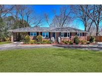 Charming brick ranch home with a well-manicured lawn and mature trees at 4212 Logan Dr, Loganville, GA 30052