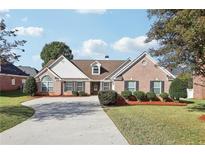 Charming single-story brick home featuring manicured landscaping and a concrete driveway at 359 Interlake Pass, Mcdonough, GA 30252