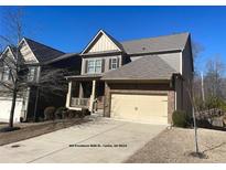 Charming two-story home featuring a brick facade, covered porch, and two-car garage at 404 Providence Walk St, Canton, GA 30114