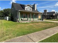 Charming one-story home with a front porch, green trim, and a well-maintained lawn at 6682 Biscayne Blvd, Rex, GA 30273