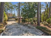Ranch style home exterior with 2-car garage and long driveway surrounded by mature trees at , Atlanta, GA 30329