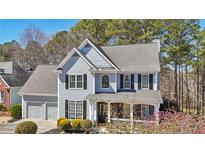 Charming two-story home with a manicured lawn, gray siding, black shutters, and a welcoming front porch at 106 Birchwood Pass, Canton, GA 30114