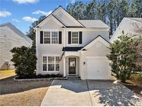 Charming two-story home with a well-manicured lawn and attached one car garage in a residential neighborhood at 1091 Dunedin Trl, Woodstock, GA 30188