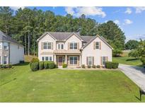 Charming two-story home with a well-manicured lawn and mature landscaping at 1516 Montauk Pt, Conyers, GA 30013