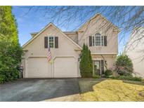 Charming two-story home boasts a two-car garage and manicured landscaping, creating a welcoming curb appeal at 5035 Foxberry Ln, Roswell, GA 30075