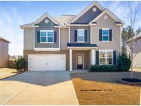 Charming two-story home featuring a spacious driveway and well-maintained lawn at 7644 Watson Cir, Locust Grove, GA 30248