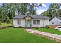 Charming bungalow with a well-maintained lawn and light blue front door at 1077 Peeples Sw St, Atlanta, GA 30310