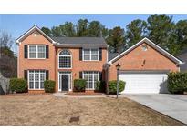 Charming two-story brick home with a well-manicured lawn and a two-car garage at 3876 Elm Trace Ct, Loganville, GA 30052