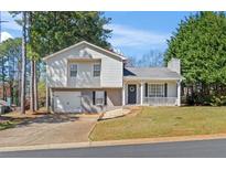 Charming split-level home featuring a two-car garage, welcoming front porch, and well-maintained lawn at 951 Orchard Mill Ln, Lawrenceville, GA 30043