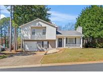 Charming two-story home with a blend of brick and siding, featuring a covered front porch, attached garage, and inviting curb appeal at 951 Orchard Mill Ln, Lawrenceville, GA 30043