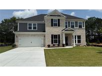 Charming two-story home featuring a brick and siding facade, an attached garage, and a well-manicured lawn at 3166 Morris Hills Dr, Dacula, GA 30019