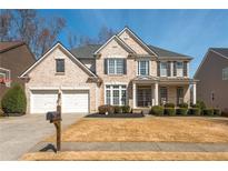 Charming two-story brick home with a well-manicured lawn and attached two-car garage at 4240 Agard St, Cumming, GA 30040