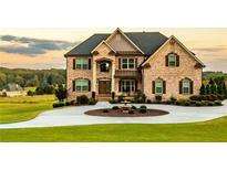 Stately brick home with manicured lawn, circular driveway, and fountain at 641 Freeman Brock Rd, Auburn, GA 30011