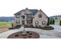 Stunning brick home featuring a circular driveway, manicured landscaping, and elegant architectural details at 641 Freeman Brock Rd, Auburn, GA 30011
