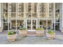 Welcoming building entrance with glass facade, flower planters, and meticulous landscaping at 2479 Peachtree Ne Rd # 508, Atlanta, GA 30305