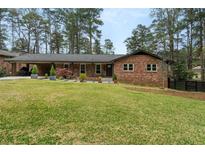 Charming brick ranch home with a well-manicured lawn and covered carport at 3504 Palace Ct, Tucker, GA 30084