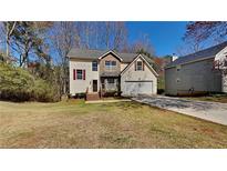 Charming two-story home featuring a well-manicured front yard and attached garage at 45 Kirkland Ct, Covington, GA 30016