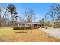 Charming brick home with a well-maintained lawn and mature trees at 1256 Highway 142 E, Covington, GA 30014