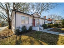 Charming single-story home with a red door, landscaped yard, and a welcoming front porch at 1416 Oglethorpe Sw Ave, Atlanta, GA 30310