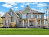 Inviting exterior showcasing a well-manicured lawn, covered porch, and architectural details at 511 Millwood Ct, Canton, GA 30114