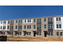 Modern townhome complex featuring brick facade, multiple windows and individual entryways under a clear, blue sky at 2664 Brookview Nw Ln, Atlanta, GA 30318