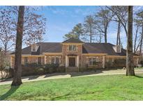 Traditional brick home with a well-manicured lawn and mature trees, offering timeless charm and curb appeal at 5110 Jett Forest Trl, Atlanta, GA 30327