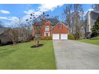 Charming two-story brick home with a well-maintained lawn, two car garage and manicured shrubbery at 3920 Lorien Nw Way, Kennesaw, GA 30152